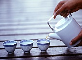 Pouring tea into Asian bowls