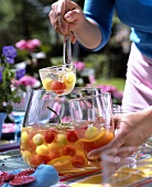 Melonen-Holunder-Bowle auf Tisch im Garten