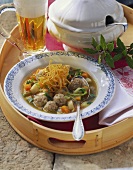 Root vegetable stew with pork dumplings; glass of beer