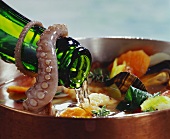 Pouring wine into seafood soup