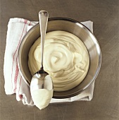Whipped cream in stainless steel bowl and on spoon