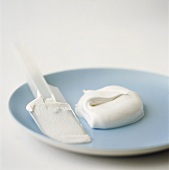 Creamy soft cheese on plate and spatula