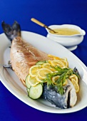 Poached salmon with slices of lemon and cucumber