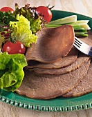 Sliced boiled beef with salad on plate