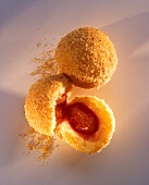 Whole and halved plum dumplings with breadcrumbs