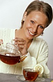 Woman Holding Pot of Tea; Cup of Tea with Lemon