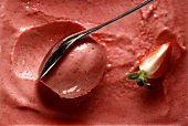 Yoghurt and strawberry ice cream in shallow dish with spoon