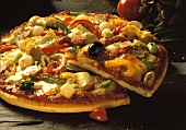 Vegetable pizza with artichokes, cut into