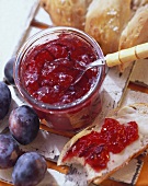 Plum jam in jar and a piece of bread and jam