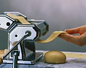 Making pasta: pulling the dough through the pasta maker
