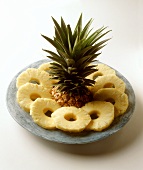 Pineapple slices and a pineapple with slices cut