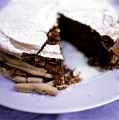 A chocolate cake with icing sugar, pieces cut