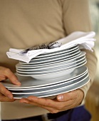 Pile of plates with napkins and cutlery