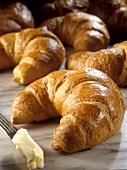 Lots of croissants and a knife with butter