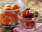 Fresh apricots and strawberries in glass jars