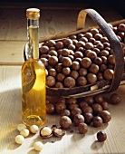Macadamia nuts in basket, bottle of macadamia oil beside it