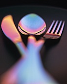 Knife, fork and spoon in red and blue light