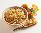 Marigold tea in wooden bowl and on scoop