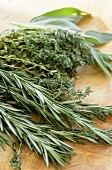 Fresh rosemary, thyme and sage on wooden background