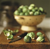 Brussels sprouts on chopping board and in colander