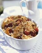 Raspberry and apricot crumble in white baking dish