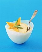 Mango mousse in bowl with spoon