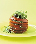Tower of tomatoes and salsa verde with rocket and olives