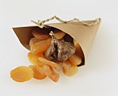 Dried apricots and fig in paper bag