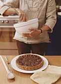Pecan pie on kitchen table, woman with mixing bowl