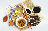 Various Asian sauces in bowls and on spoons