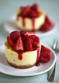 Round cheesecakes with berries and fruit sauce