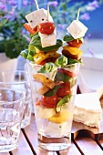 Skewered vegetables with cheese and basil in glass