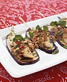 Chicken skewers with peanut sauce on grilled aubergines
