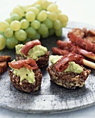 Red rice cakes with avocado dip and bresaola, green grapes
