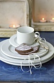 Pieces of chocolate cake with icing sugar beside coffee cup