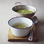 Soaked dried peas in an enamel bowl