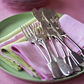 Decorative silver forks and fish knives on fabric napkins