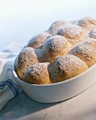 Buchteln (baked yeast dumplings) with icing sugar in baking dish