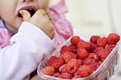 Child eating raspberries