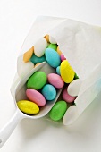 Sugared almonds in paper bag with scoop
