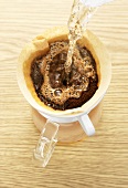 Pouring hot water onto ground coffee in coffee filter