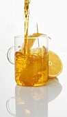 Zitronentee in Glas einschenken