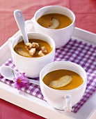 Carrot and apple soup with croutons in three cups