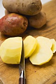 Peeled red potato, partly sliced