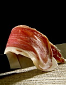 A slice of Serrano ham on knife