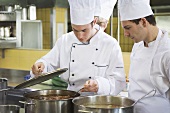 Chefs examining the contents of a pan