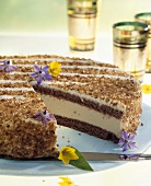 Tea punch cake with edible flowers, a piece taken