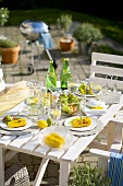 Grilled corn cobs and salad on table out of doors