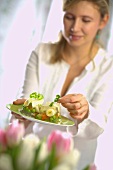 Woman garnishing vegetables in aspic with parsley