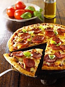 Pizza mit Peperoniwurst, angeschnitten